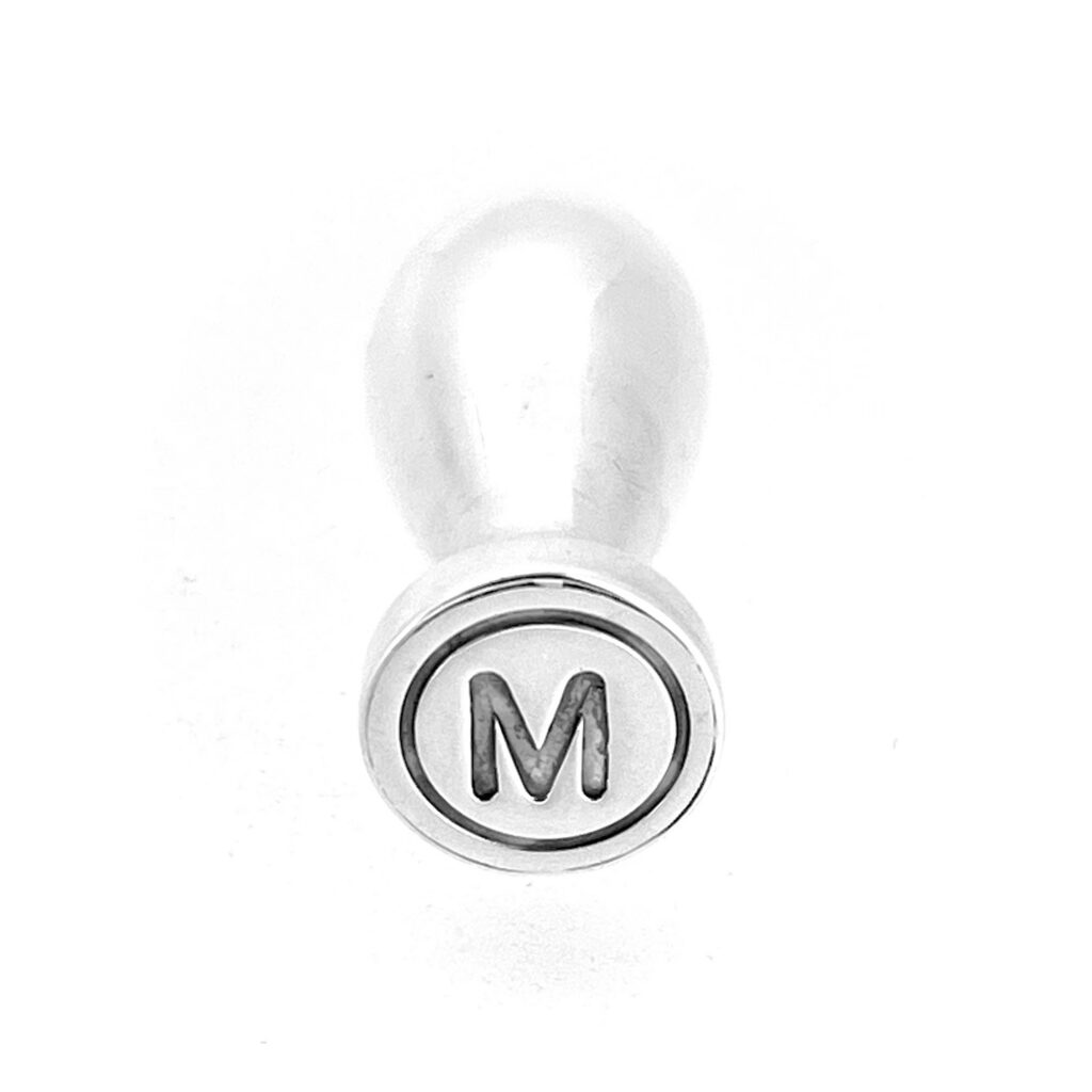 Close up of letter M seal face on sterling silver wax seal